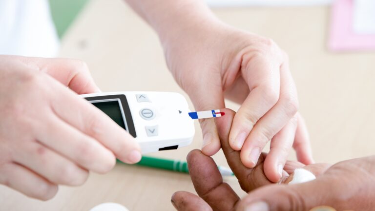 What causes diabetes? A nurse checking someone with diabetes