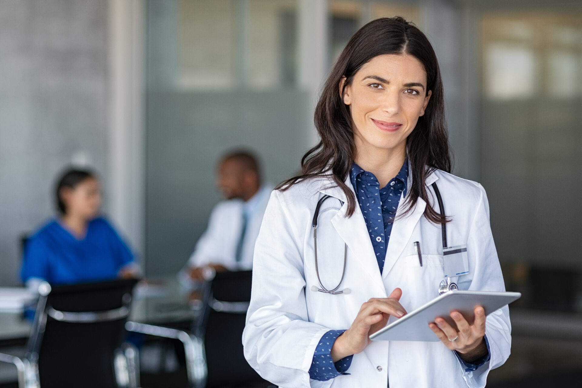 Local Primary Care Memberships with a Doctor holding digital tablet at meeting room