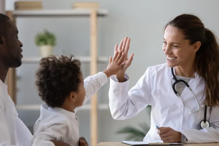 Smiling female doctor give high five to little biracial patient. Better Healthcare