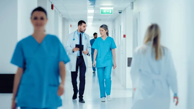 Surgeon and Female Doctor Walk Through Hospital Hallway. Traditional Health Insurance