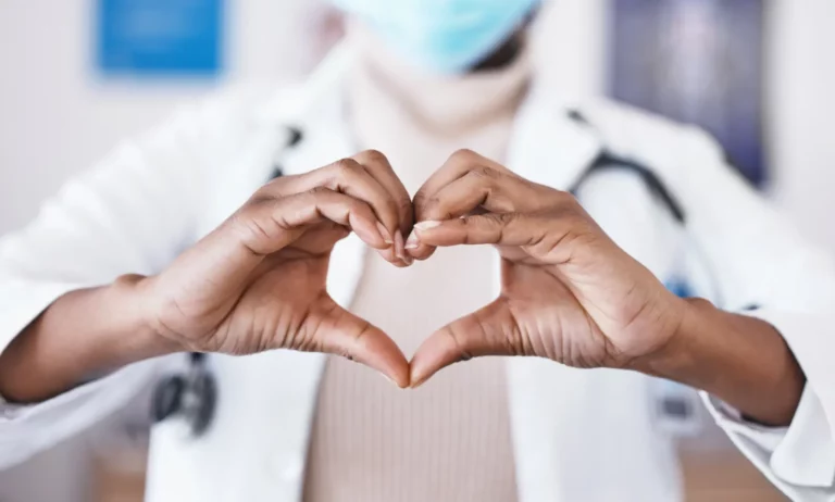 Holistic Care. Closeup nurse holding out hands in heart shape