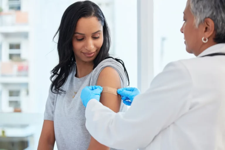 Why Consider DPC nurse applying bandaid to patients shoulder.