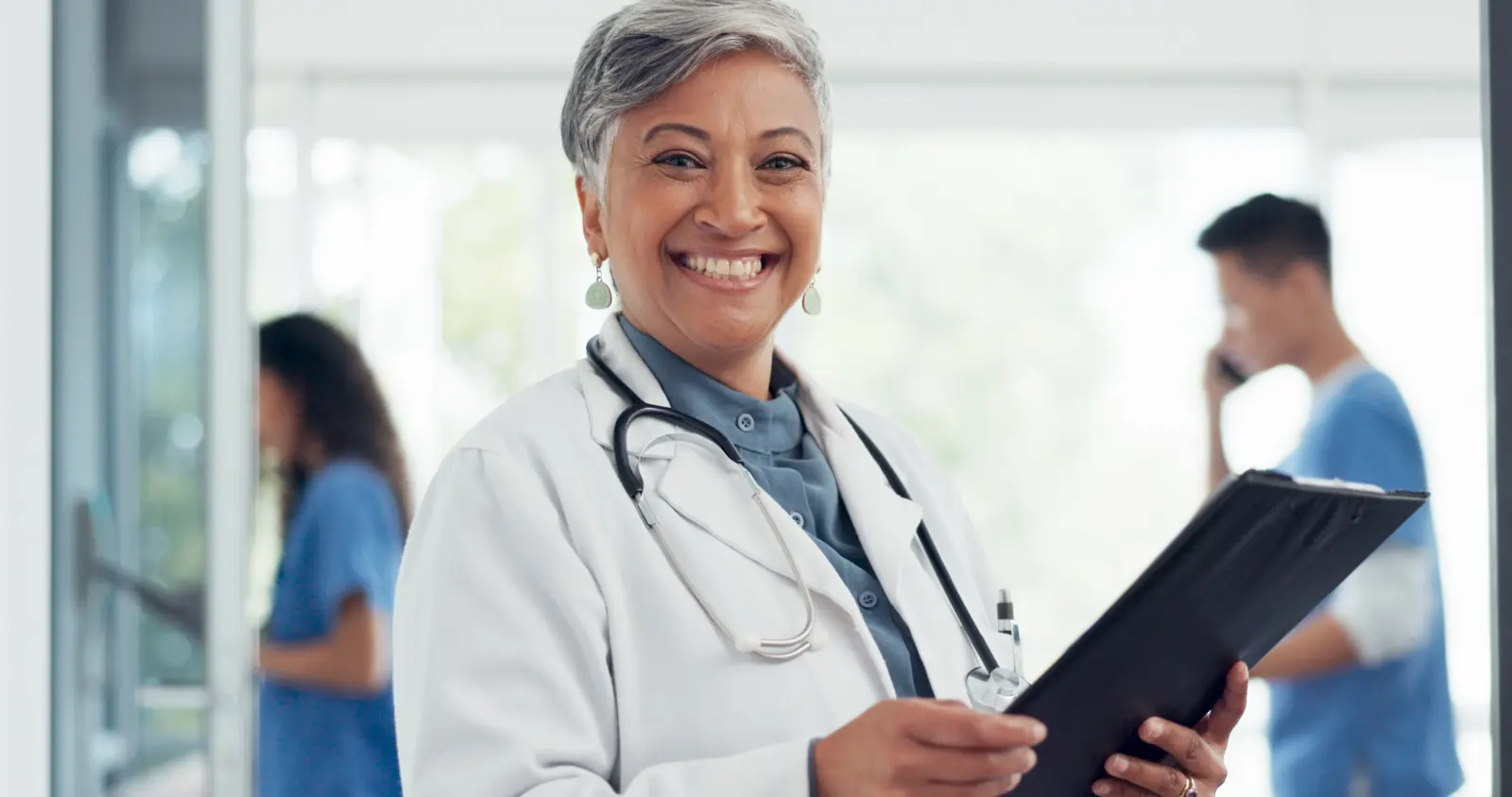 portrait doctor smiling in hallway that is why Subscription-Based Primary Care is the best